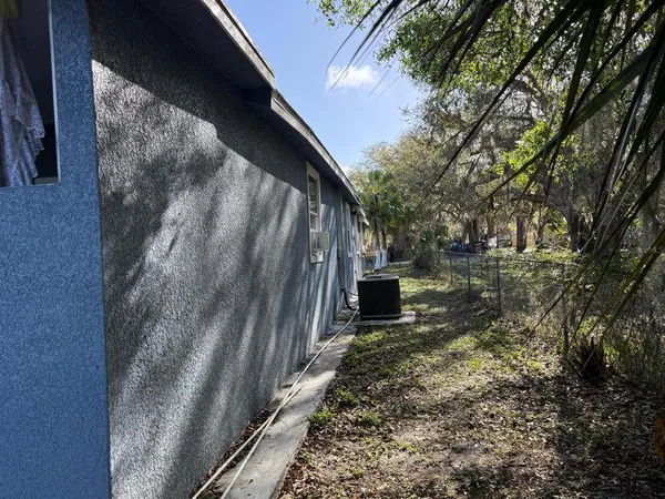 a view of backyard with wooden fence and large trees