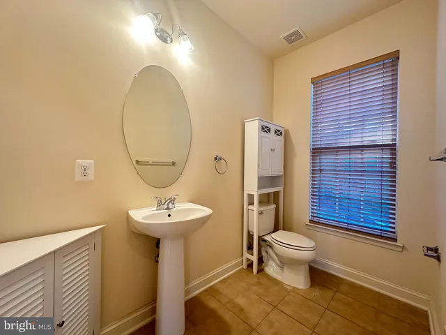 a bathroom with a sink toilet and a mirror