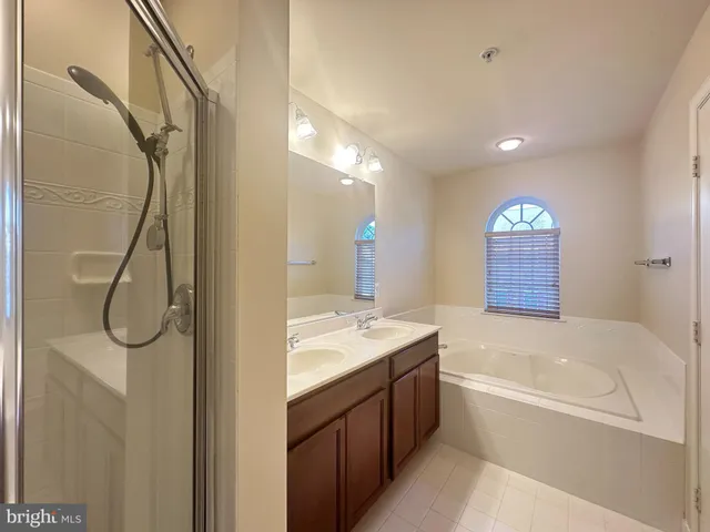 a bathroom with a granite countertop sink a vanity a mirror and a bathtub