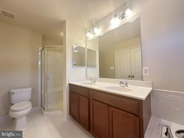 a spacious bathroom with a toilet a sink and mirror