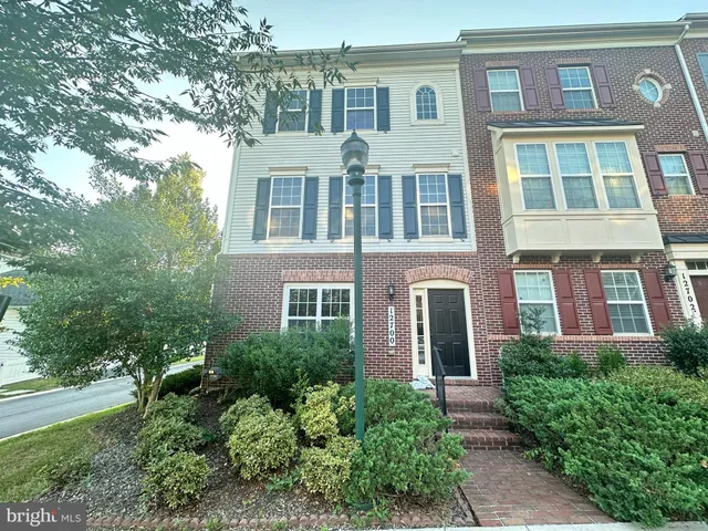 front view of a brick house with a yard