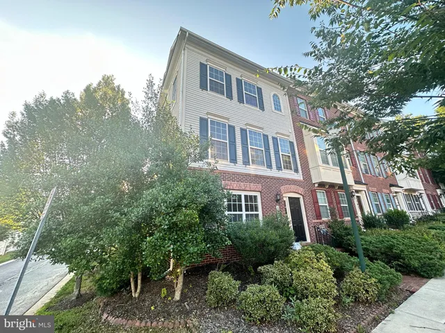 a front view of a house with trees and plants