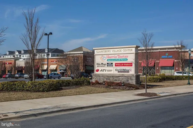 a front view of a house with a yard and a bench under umbrellas