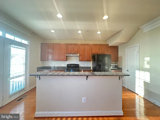 a kitchen with stainless steel appliances granite countertop a sink a stove top oven a counter space and cabinets