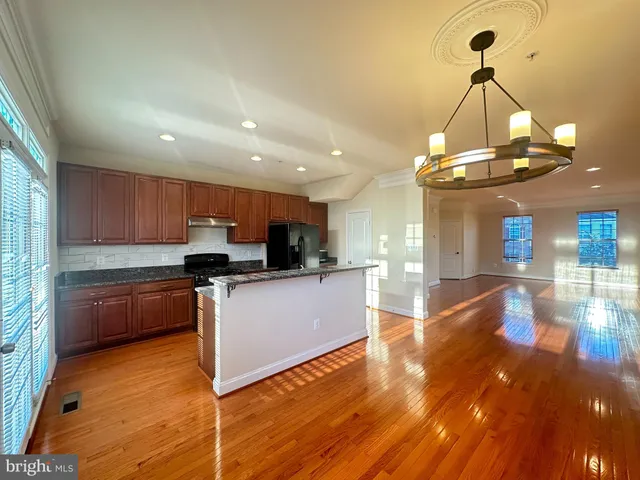 a kitchen with stainless steel appliances granite countertop a sink a stove top oven a counter space and cabinets