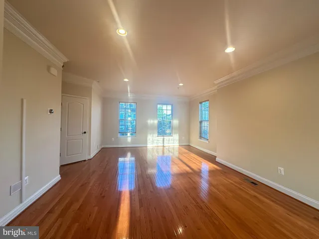a view of empty room with wooden floor