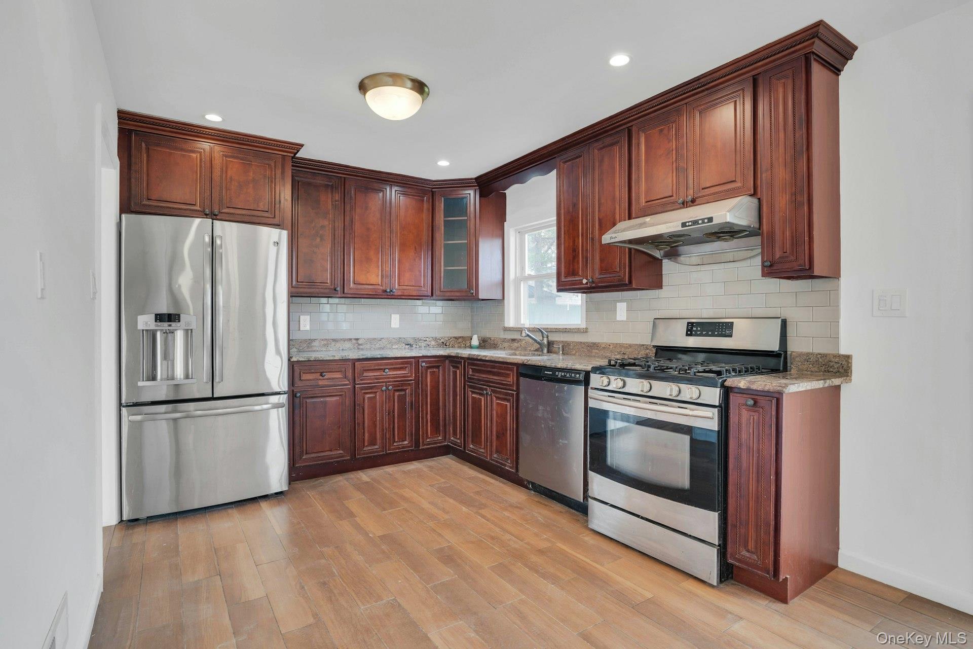 44 Delaware Avenue Commack, NY 11725 - Photo 12 of 34 a kitchen with stainless steel appliances granite countertop a refrigerator stove and sink