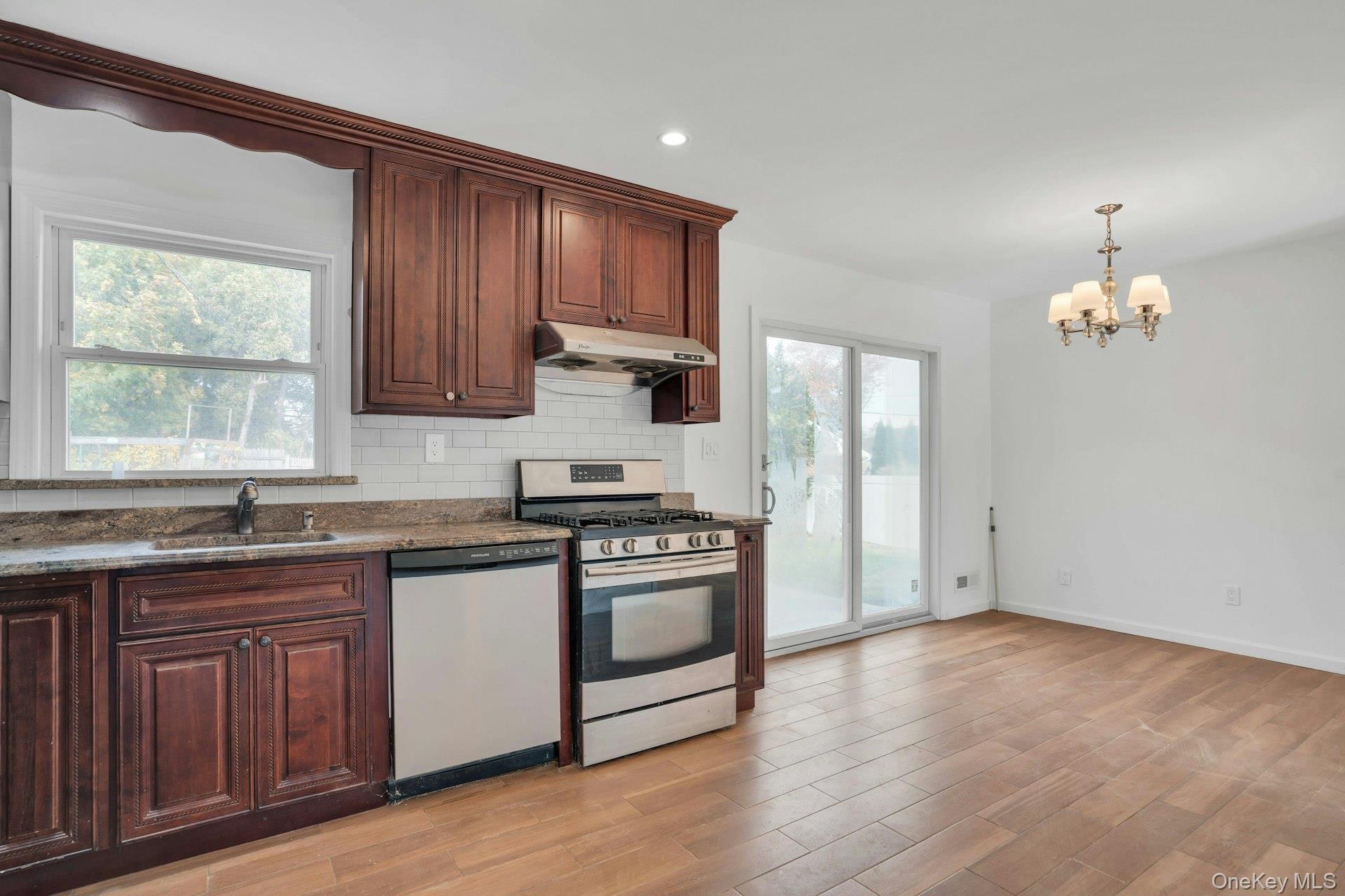 44 Delaware Avenue Commack, NY 11725 - Photo 14 of 34 a kitchen with a sink stove and cabinets