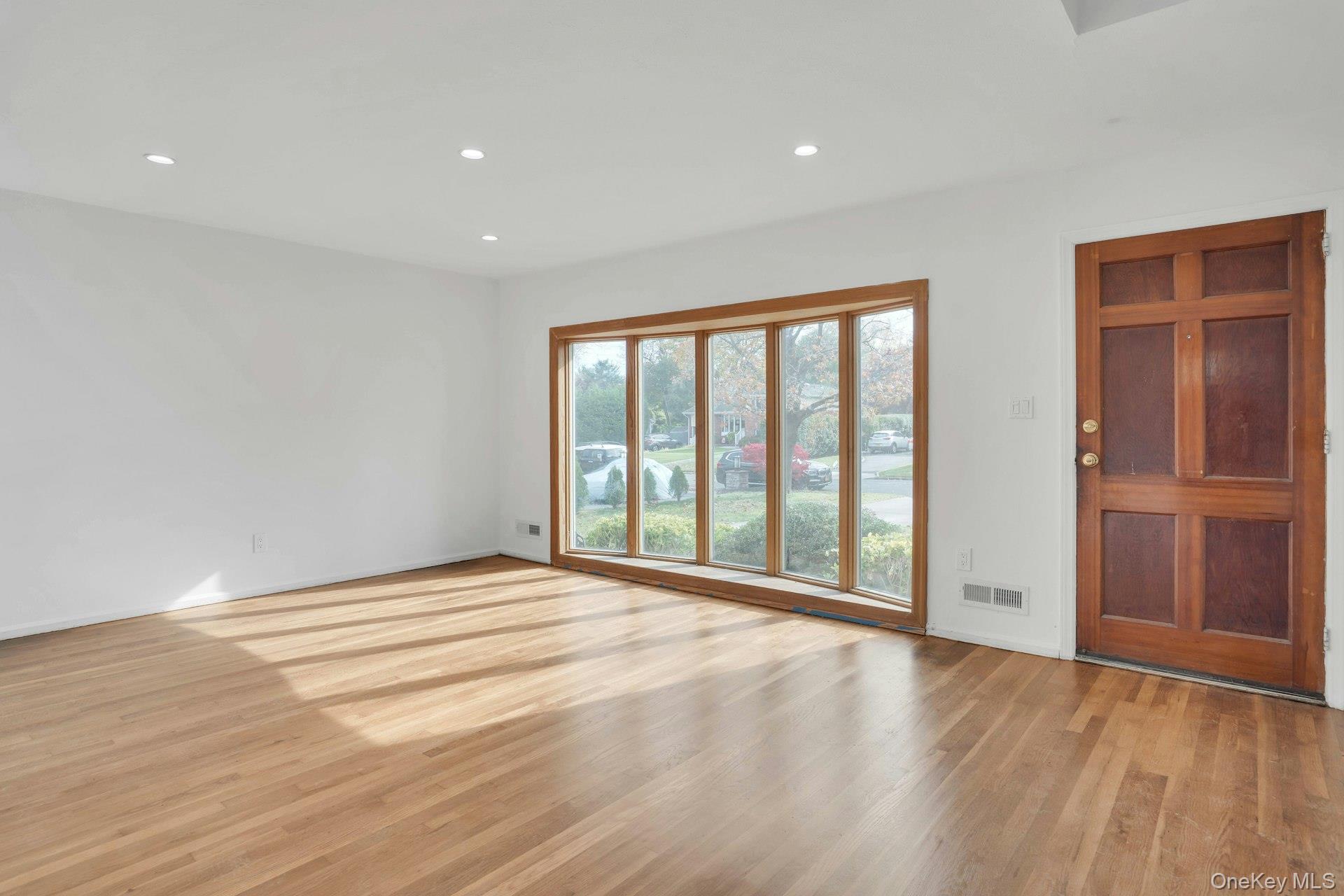 44 Delaware Avenue Commack, NY 11725 - Photo 8 of 34 a view of an empty room with wooden floor and a window
