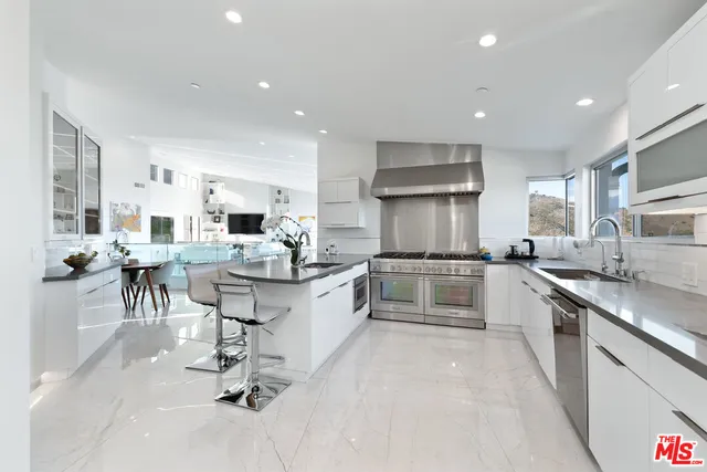 a kitchen with stainless steel appliances granite countertop a refrigerator and a sink