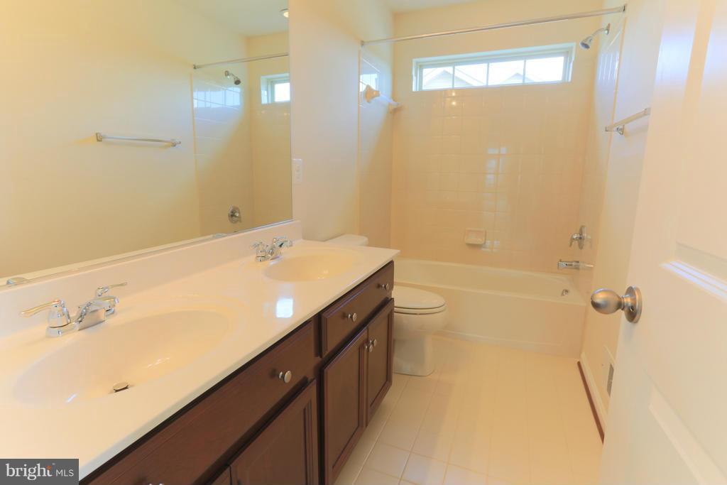 4410 Pensel Road Perry Hall, MD 21128 - Photo 21 of 30 a bathroom with a double vanity sink a toilet and a bathtub