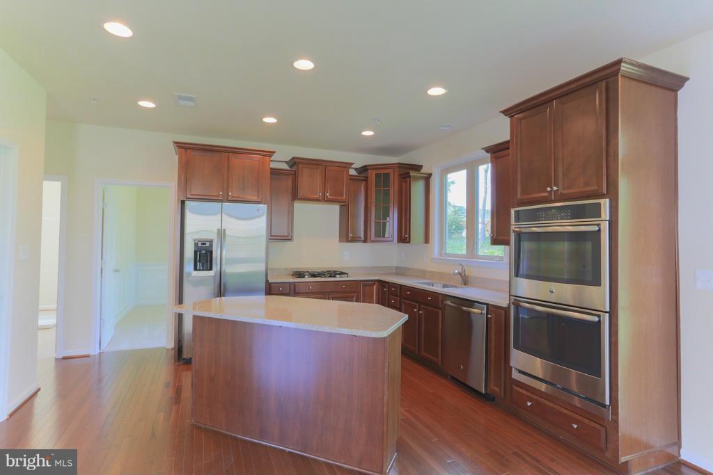 4410 Pensel Road Perry Hall, MD 21128 - Photo 9 of 30 a large kitchen with stainless steel appliances granite countertop a refrigerator a sink a stove and island