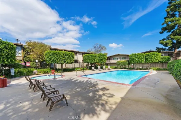 an aerial view of a swimming pool with a yard and parking