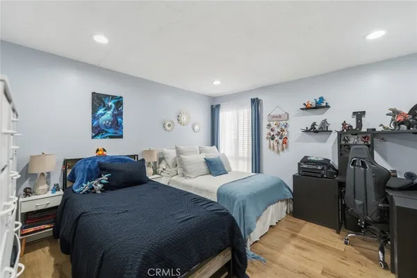 a bedroom with a bed and wooden floor