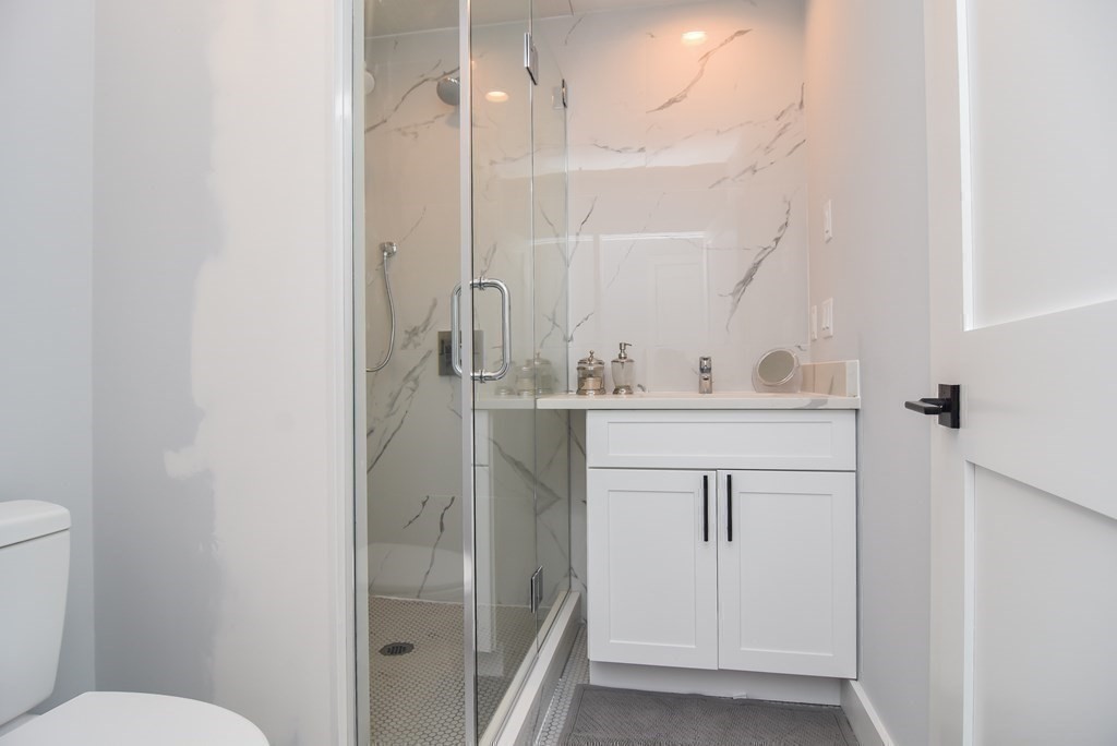 3850 Washington Street, Unit 1 Boston, MA 02131 - Photo 17 of 23 a bathroom with a sink a toilet a mirror and shower