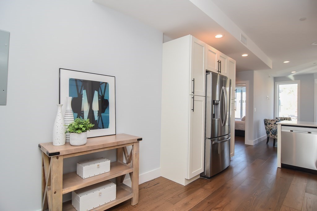 3850 Washington Street, Unit 1 Boston, MA 02131 - Photo 5 of 23 a kitchen with stainless steel appliances a refrigerator and a wooden floor