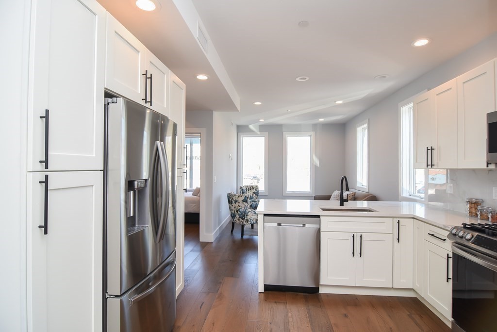 3850 Washington Street, Unit 1 Boston, MA 02131 - Photo 10 of 23 a kitchen with stainless steel appliances a refrigerator sink and cabinets