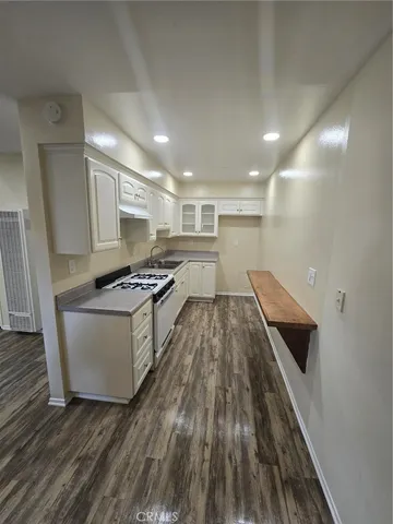 a kitchen with a sink and wooden floor