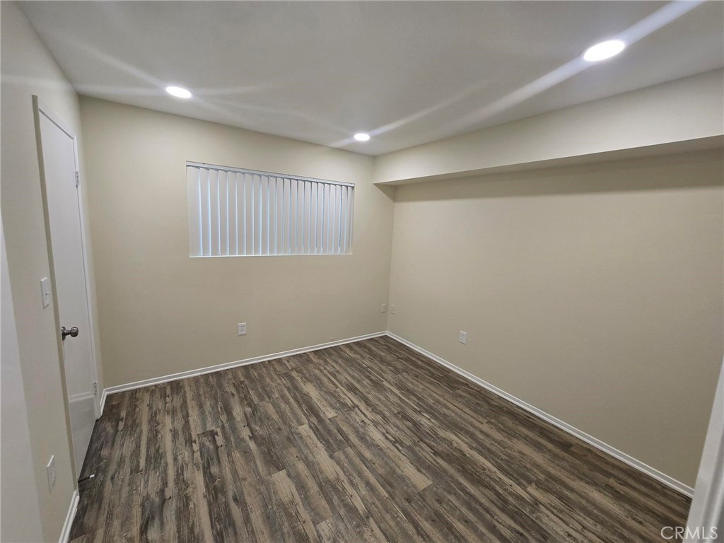 220 12th Street, Unit 8 Huntington Beach, CA 92648 - Photo 7 of 10 an empty room with wooden floor and windows