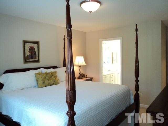 6900 Wilderness Road Raleigh, NC 27613 - Photo 12 of 25 a bedroom with a bed and a painting on the wall