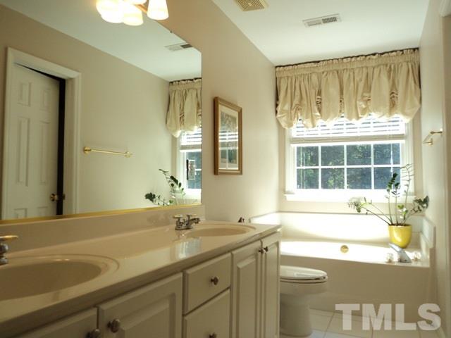 6900 Wilderness Road Raleigh, NC 27613 - Photo 13 of 25 a bathroom with a sink and a large mirror