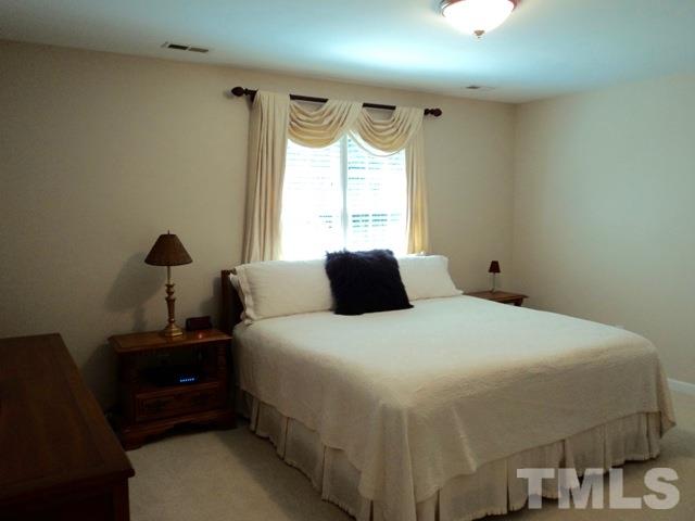 6900 Wilderness Road Raleigh, NC 27613 - Photo 17 of 25 a bedroom with a bed and a window