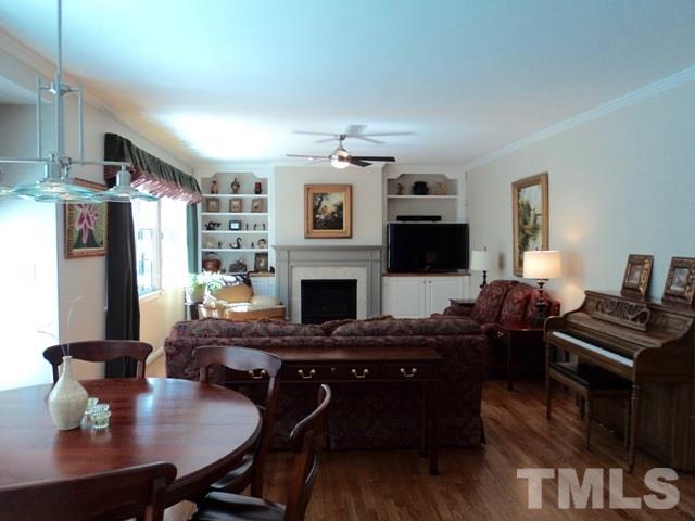 6900 Wilderness Road Raleigh, NC 27613 - Photo 6 of 25 a living room with furniture a flat screen tv and a fireplace