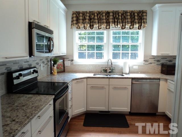 6900 Wilderness Road Raleigh, NC 27613 - Photo 7 of 25 a kitchen with a sink and a stove