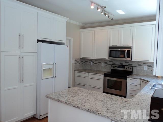 6900 Wilderness Road Raleigh, NC 27613 - Photo 9 of 25 a kitchen with cabinets appliances and a counter space