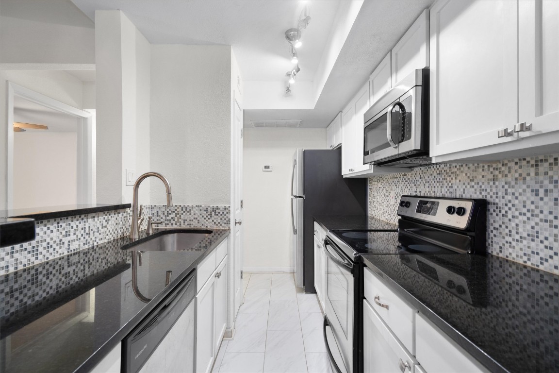 a kitchen with stainless steel appliances granite countertop a sink stove and cabinets