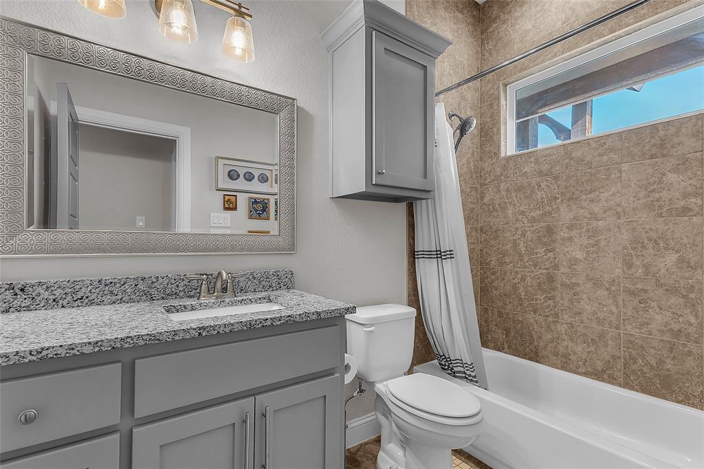 1014 Rennard Street Caddo Mills, TX 75135 - Photo 28 of 39 Full bathroom featuring a light gray vanity with a granite countertop and shower/tub combo