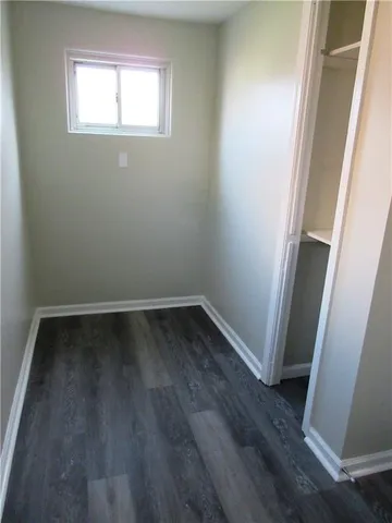 a view of a small space with wooden floor and window