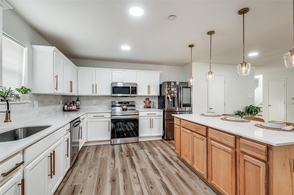 2416 Big Spring Drive Fort Worth, TX 76120 - Photo 13 of 36 a kitchen with stainless steel appliances granite countertop a sink a stove and a refrigerator
