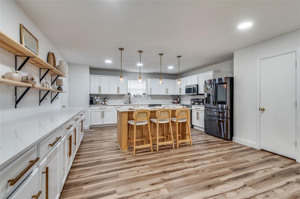 2416 Big Spring Drive Fort Worth, TX 76120 - Photo 18 of 36 a kitchen with stainless steel appliances kitchen island granite countertop a refrigerator and a sink