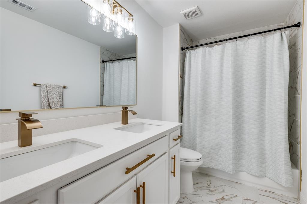 2416 Big Spring Drive Fort Worth, TX 76120 - Photo 34 of 36 a bathroom with a sink a toilet and shower curtain