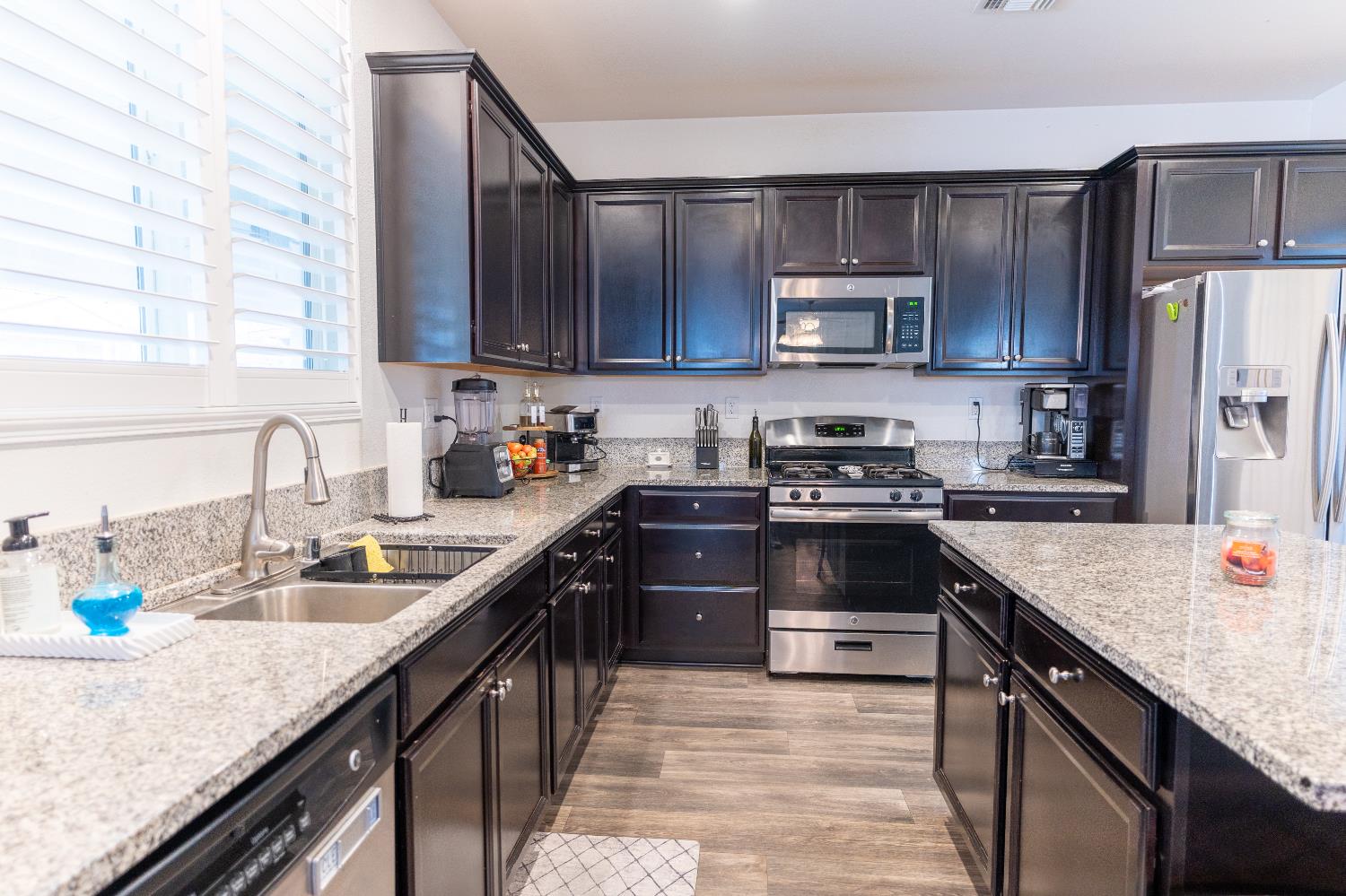 1358 Tevin Way Madera, CA 93637 - Photo 4 of 13 a kitchen with granite countertop a sink a stove and refrigerator