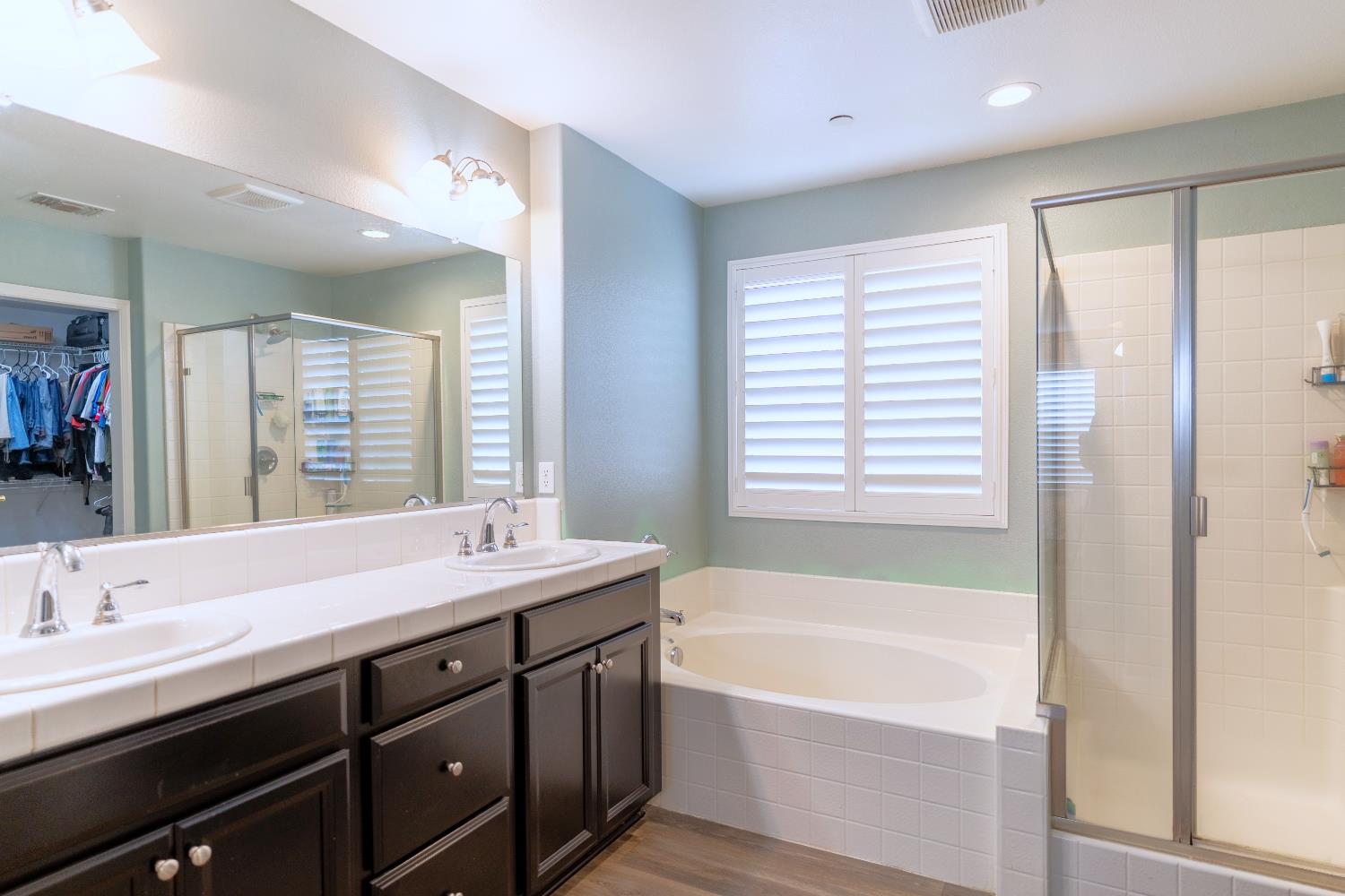 1358 Tevin Way Madera, CA 93637 - Photo 7 of 13 a bathroom with a tub sink double vanity and mirror