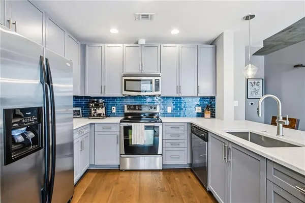 a kitchen with a sink cabinets and stainless steel appliances