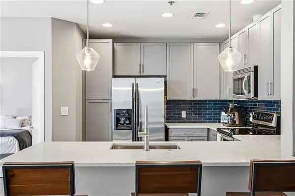 a kitchen with stainless steel appliances granite countertop a sink and a refrigerator