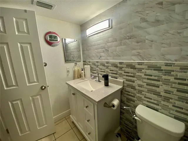 a bathroom with a granite countertop toilet sink and mirror