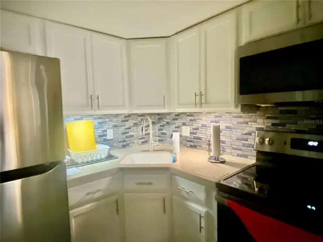 a kitchen with a sink a stove and a refrigerator