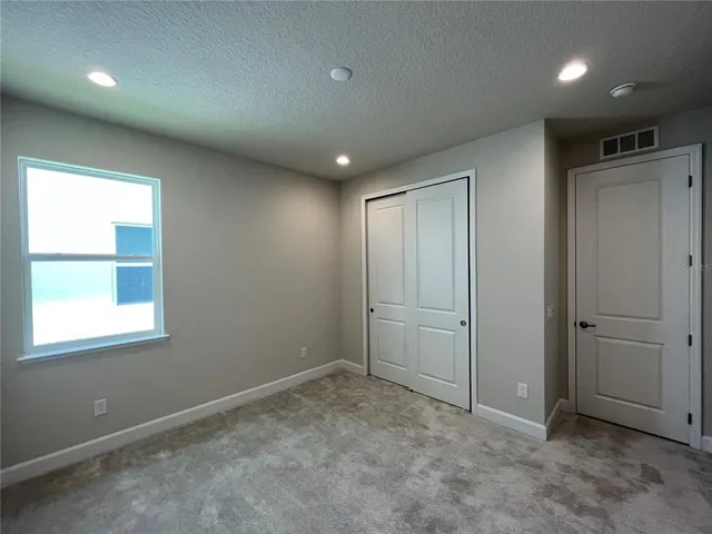 an empty room with windows and closet