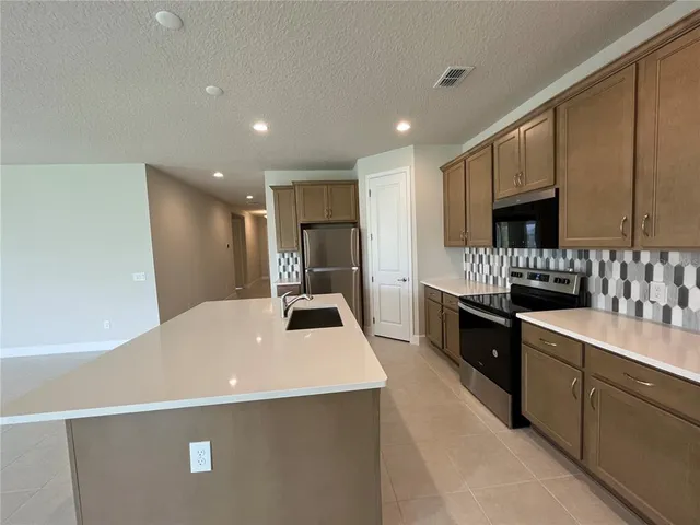 a kitchen with a sink a stove and a refrigerator