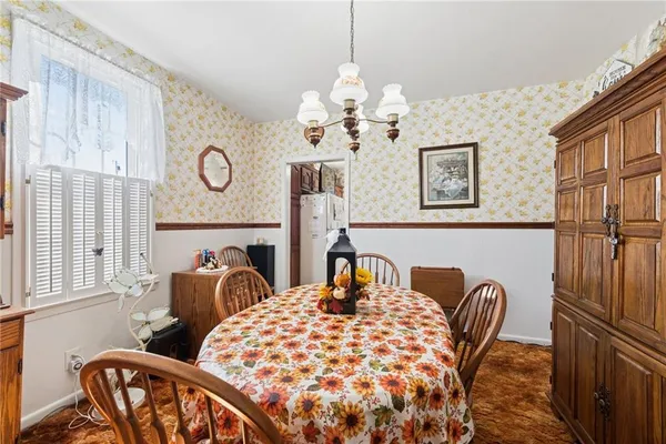 a view of a dining room with furniture and a chandelier
