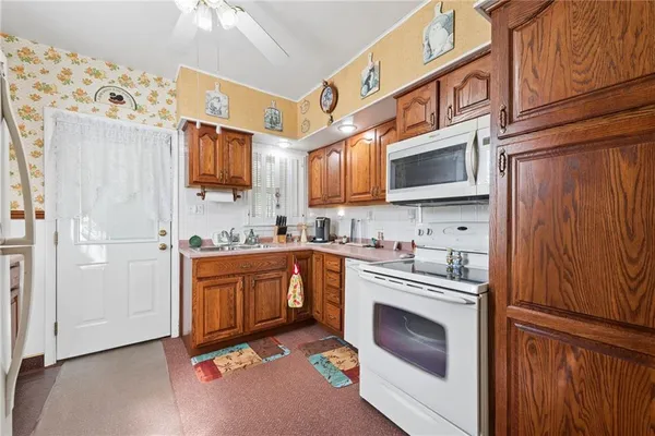 a kitchen with stainless steel appliances granite countertop a stove a sink and a microwave