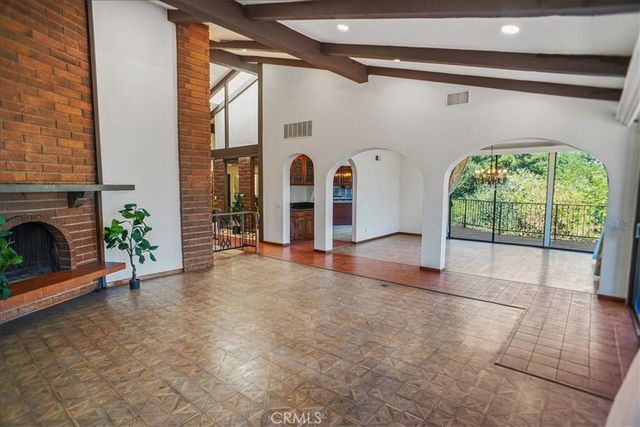 a view of an empty room with a fireplace and windows