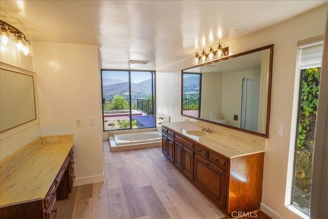 a spacious bathroom with a double vanity sink a large mirror and a bathtub