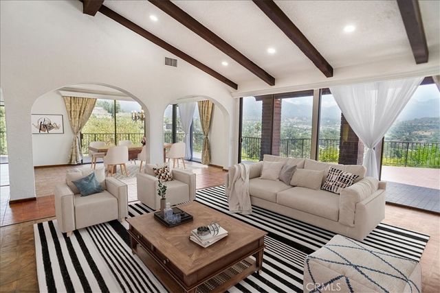 a living room with furniture a large window and a table