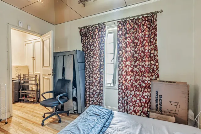 a bedroom with a bed and wooden floor