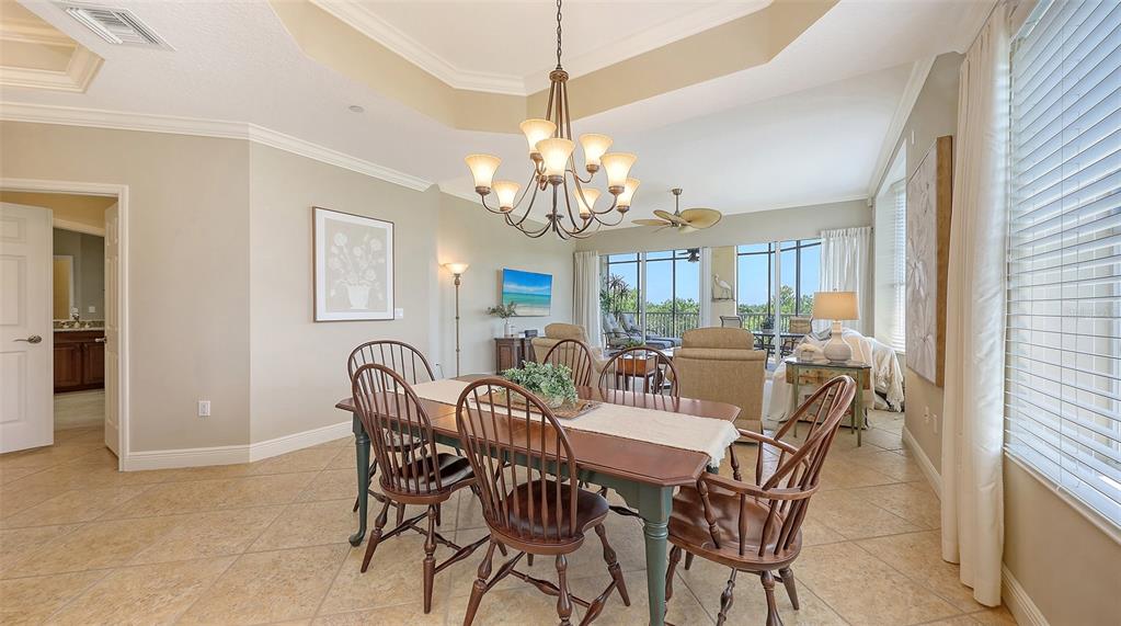 6465 Water Crest Way, Unit 404 Lakewood Ranch, FL 34202 - Photo 13 of 62 a view of a dining room with furniture and chandelier